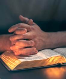 A person's hands folded over a book

AI-generated content may be incorrect.